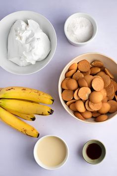 bananas, almonds, yogurt and other ingredients are arranged on a table