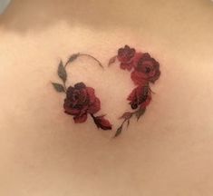 a woman's back with red roses in the shape of a heart on it