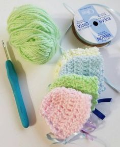 three balls of yarn next to a crochet hook