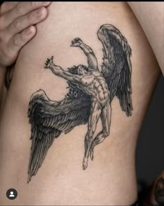 a man with an angel tattoo on his stomach holding onto the side of his body