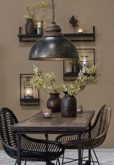 a wooden table topped with vases filled with flowers next to two wicker chairs