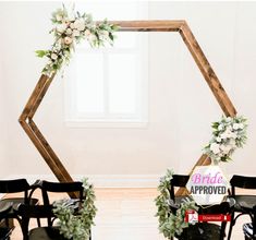 the chairs are set up with flowers and greenery on them for a wedding ceremony