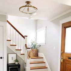 there is a basket on the stairs next to the door and a rug in front of it