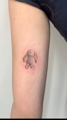 a small tattoo on the leg of a woman's arm with a rabbit drawn on it