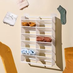 a pair of shoes hanging on a wall next to a chair and clothes drying rack