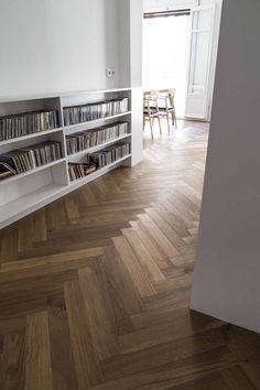 an empty room with bookshelves and wooden floors