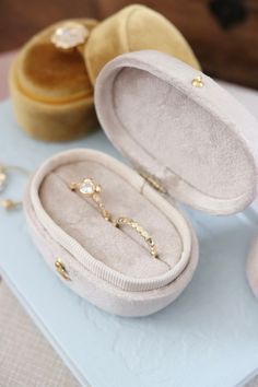 an open ring box sitting on top of a table next to other rings and jewelry