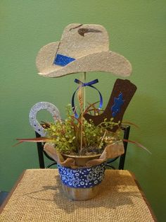 a potted plant sitting on top of a wooden table next to a cowboy hat