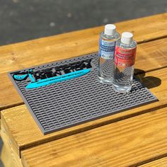 two bottles of water sitting on top of a wooden table next to a bottle opener