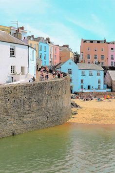 a group of people sitting on top of a beach next to buildings