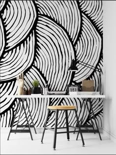 an artistic wallpaper design with black and white swirls on the walls, along with two stools