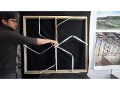 a man is working on some kind of art project in front of a blackboard