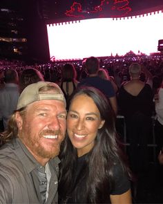 a man and woman taking a selfie in front of an audience at a concert