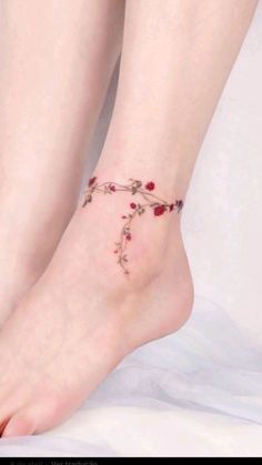 a woman's foot with a rose tattoo on the side of her leg,