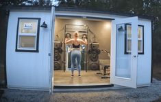 a woman is standing in the doorway of a small shed with her back to the camera