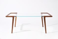 a glass table with wooden legs on a white background