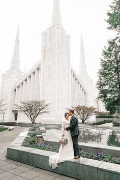 a bride and groom pose in front of the mormon temple