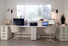 an office with two computer desks and white chairs