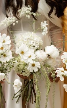 two bridesmaids holding bouquets of white flowers