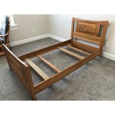 a wooden bed frame sitting on top of a carpeted floor