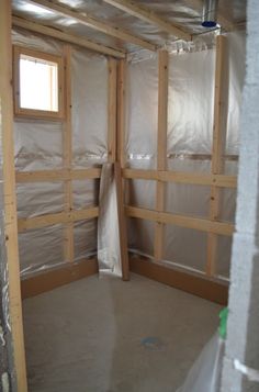 an unfinished room with wood framing on the walls and drywall in place for insulation