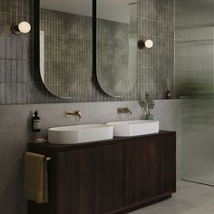 a bathroom with two sinks and mirrors on the wall