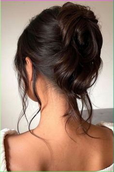 a woman's back with her hair in a low bun, looking to the side