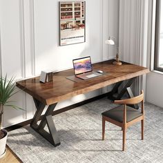 a wooden desk with a laptop on top of it next to a chair and potted plant