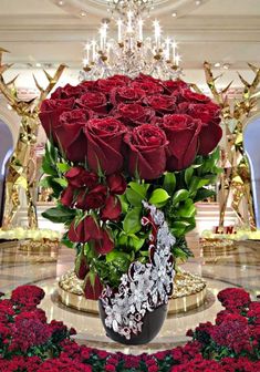 a large vase filled with lots of red roses