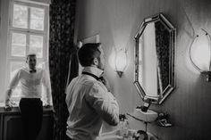 a man standing in front of a bathroom mirror