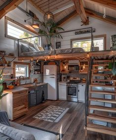 a kitchen and living room in a tiny house with stairs leading up to the loft