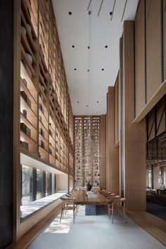 an empty room with tables and chairs in front of a wall full of bookshelves