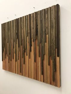 a wooden wall hanging on the side of a white wall