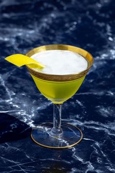 a yellow cocktail sitting on top of a table