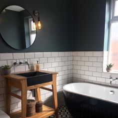 a black and white bathroom with a sink, toilet and bathtub next to a window