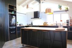 a kitchen with black cabinets and an island in front of the stove top ovens