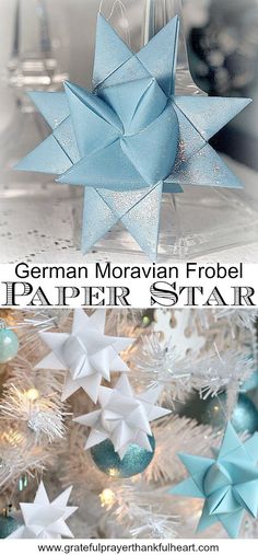 an origami star hanging from a christmas tree with blue and white ornaments around it