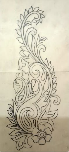 an intricately designed tattoo design on the side of a sheet of paper with black ink