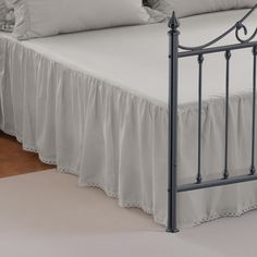 a bed with white sheets and pillows on top of it