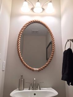 a bathroom with a sink, mirror and towel hanging on the wall in front of it