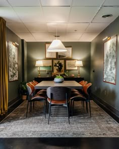 the dining room table is surrounded by orange chairs and black tables with matching upholstered lamps