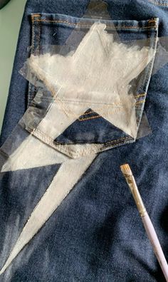 a pair of blue jeans with white stars on them and a pen sticking out of the pocket