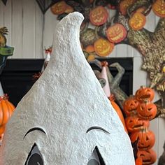 a halloween decoration with pumpkins in the background and a face painted on it's side