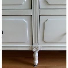 an old white kitchen cabinet with knobs and handles