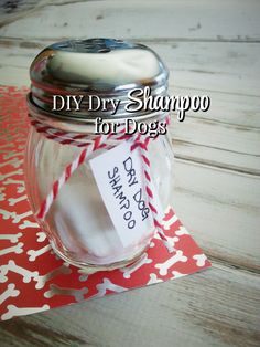 a glass jar filled with dog treats on top of a red and white table cloth