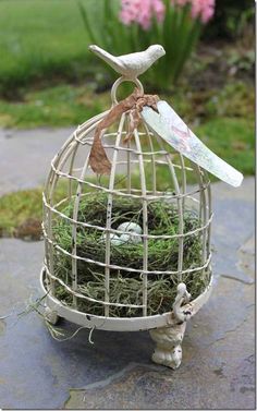 a small bird cage with some grass in it