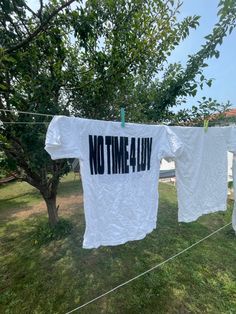 two t - shirts that say no time 4 luv hanging on a clothes line