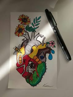 a drawing of a heart with flowers on it and a black marker next to it