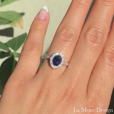 a woman's hand with a ring on it and an oval blue stone in the middle