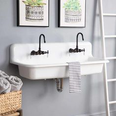 a bathroom with two sinks and a ladder hanging on the wall next to each other